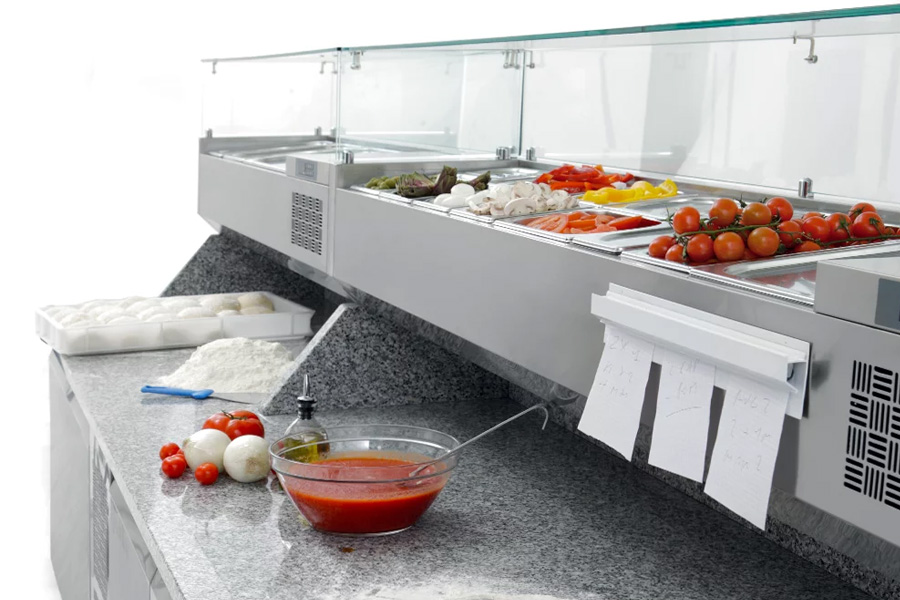 Coldline Aufsatzkühlvitrine mit Schutzglas über GN-Zutatenbehältern auf einem Pizzakühltisch mit Granitarbeitsplatte